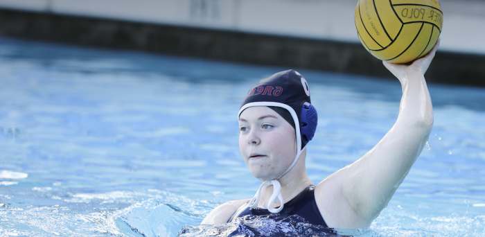 A women's water polo player throwing the ball