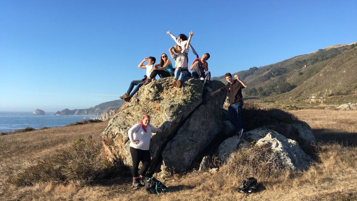 实地考察的EES学生在海边的岩石上摆姿势